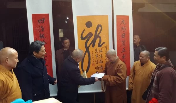 著名佛教丛林新都宝光寺举办“龙佑中华”民俗活动(图4) 方丈意寂大和尚接过单成武的“龙”字和研究文章