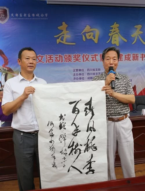 四川省作协原副主席、四川省文艺传播促进会会长何开四向成都高新区锦城小学校长杨秀东赠送书法作品