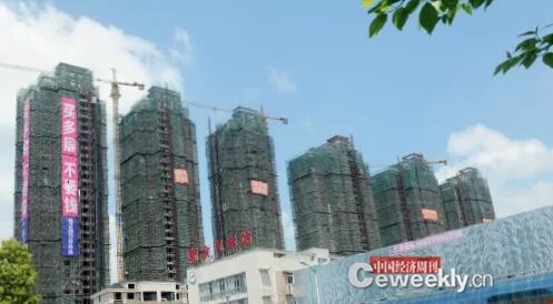 江西四地去库存调查:最大库存消化需10年(图2) p18-新余市房产商打出吸引客户买房的标语 摄影 上官丽娟