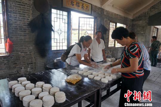 游客在兴安灵渠人家“三米驿站”体验打糍粑。　赵琳露 摄