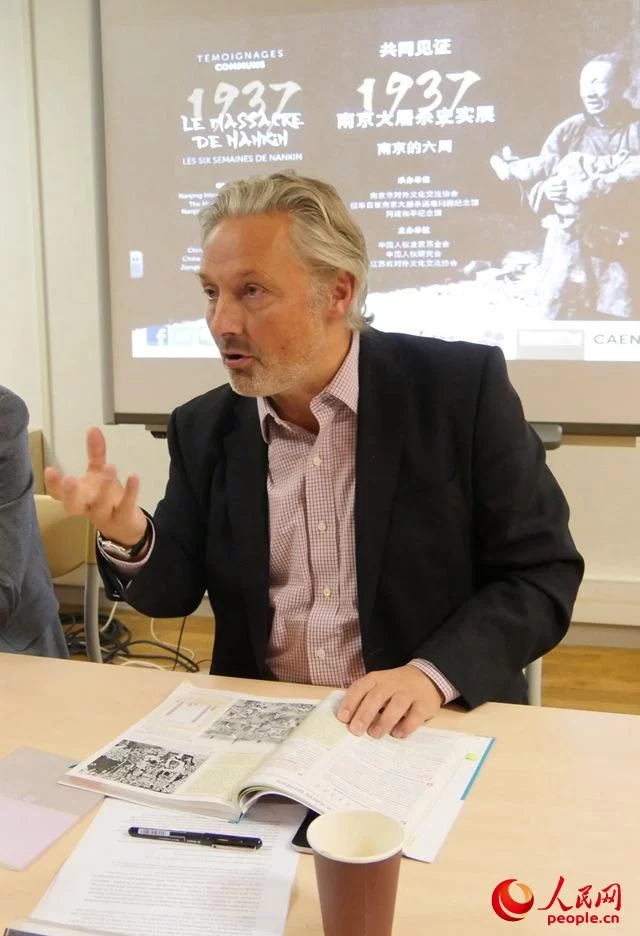 让更多的欧洲人了解南京大屠杀史实 中法二战主题展馆签署友好合作协议(图1) 冈城和平纪念馆馆长格里马尔迪向记者展示登有南京大屠杀照片的法国新版中学历史教科书。王芳摄