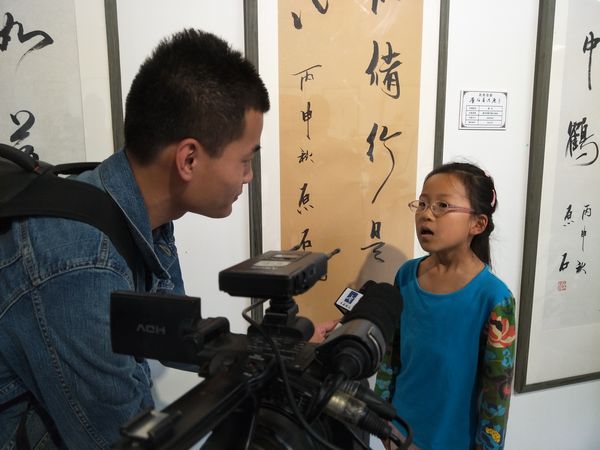 自然弥新——原石书法展在京开幕(图7) 媒体采访参加开幕式的小朋友