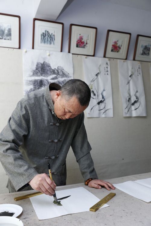 自然之韵在画中——记国家一级画师侯喜林艺术创作情怀(图2) 候喜林先生专心创作水墨游虾图