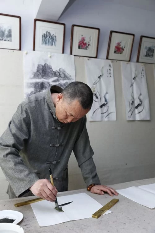 自然之韵在画中——记国家一级画师侯喜林艺术创作情怀(图2) 候喜林先生专心创作水墨游虾图