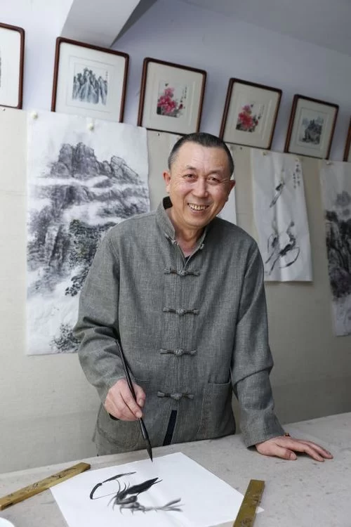 自然之韵在画中——记国家一级画师侯喜林艺术创作情怀(图1) 候喜林先生正在创作水墨游虾图