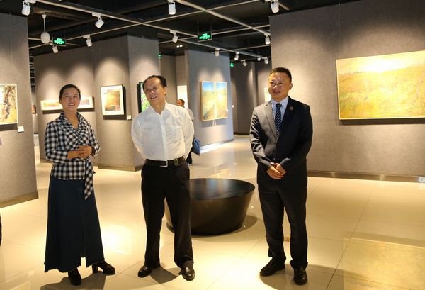 善行天下 大美凉山 ——好医生福能源举办公益画展(图3) 董事长耿福能,总经理耿越昌与艺术家孙蕾观展交流