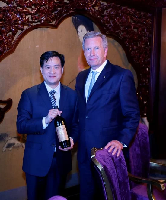 全球中小企业联盟主席、德国前总统武尔夫和全球中小企业联盟秘书长曹方与“神沟九寨红”合影