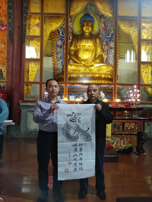 弘扬真善美 单成武书画作品“佛”“虎啸”亮相峨眉山伏虎寺(图4) 单成武老师向国智智库负责人赠送翰墨丹青,希望进一步传承弘扬优秀传统文化